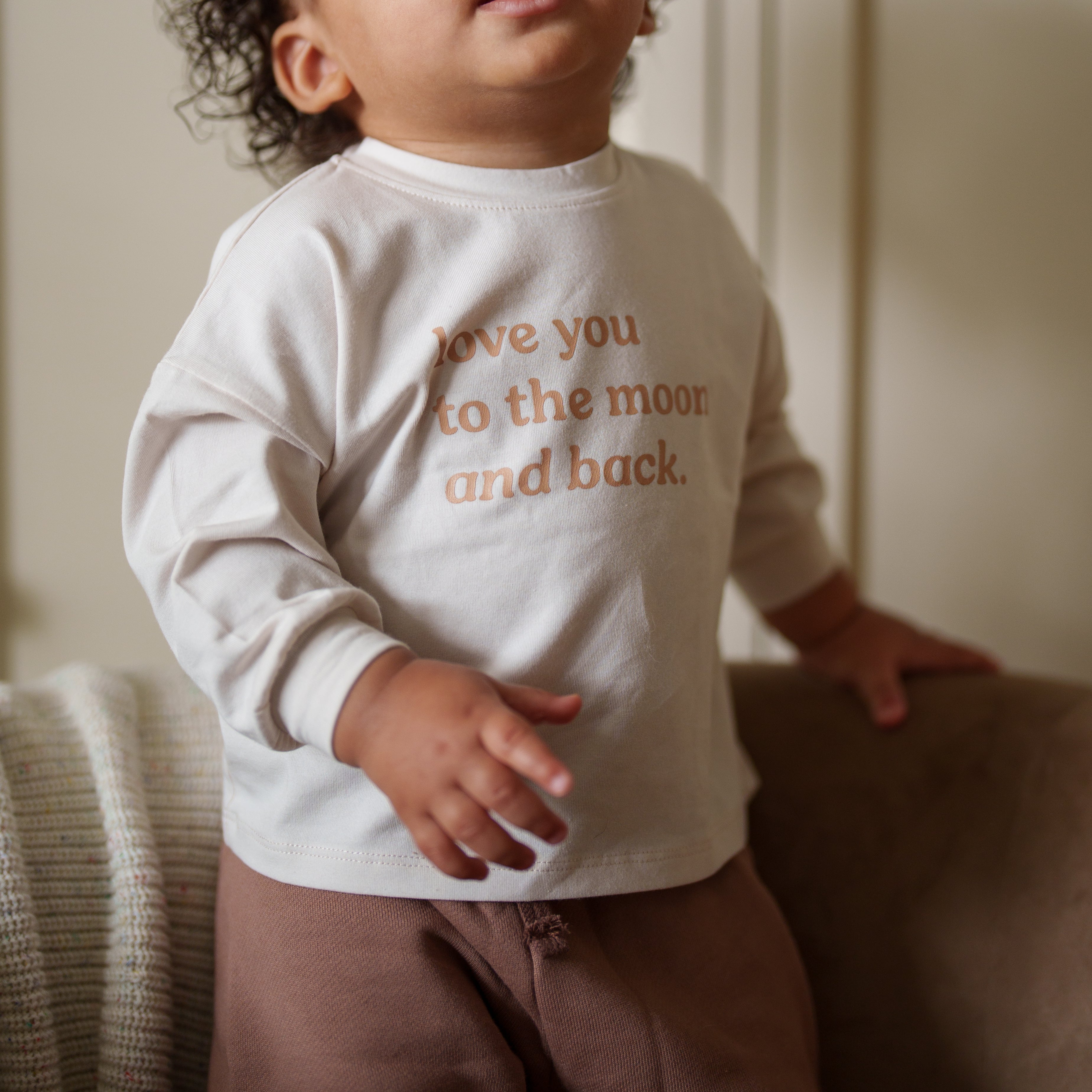 Love You to the Moon and Back Organic Longsleeve worn by a toddler, featuring a heartfelt message on a cozy top.
