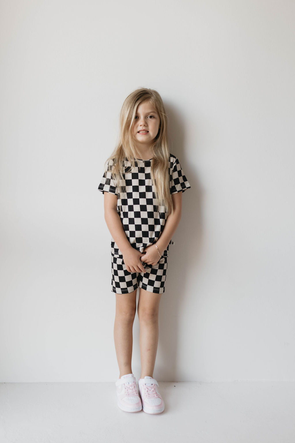 Toddler wearing a black checkerboard bamboo short set, perfect for summer lounge, featuring a relaxed-fit tee and matching shorts.