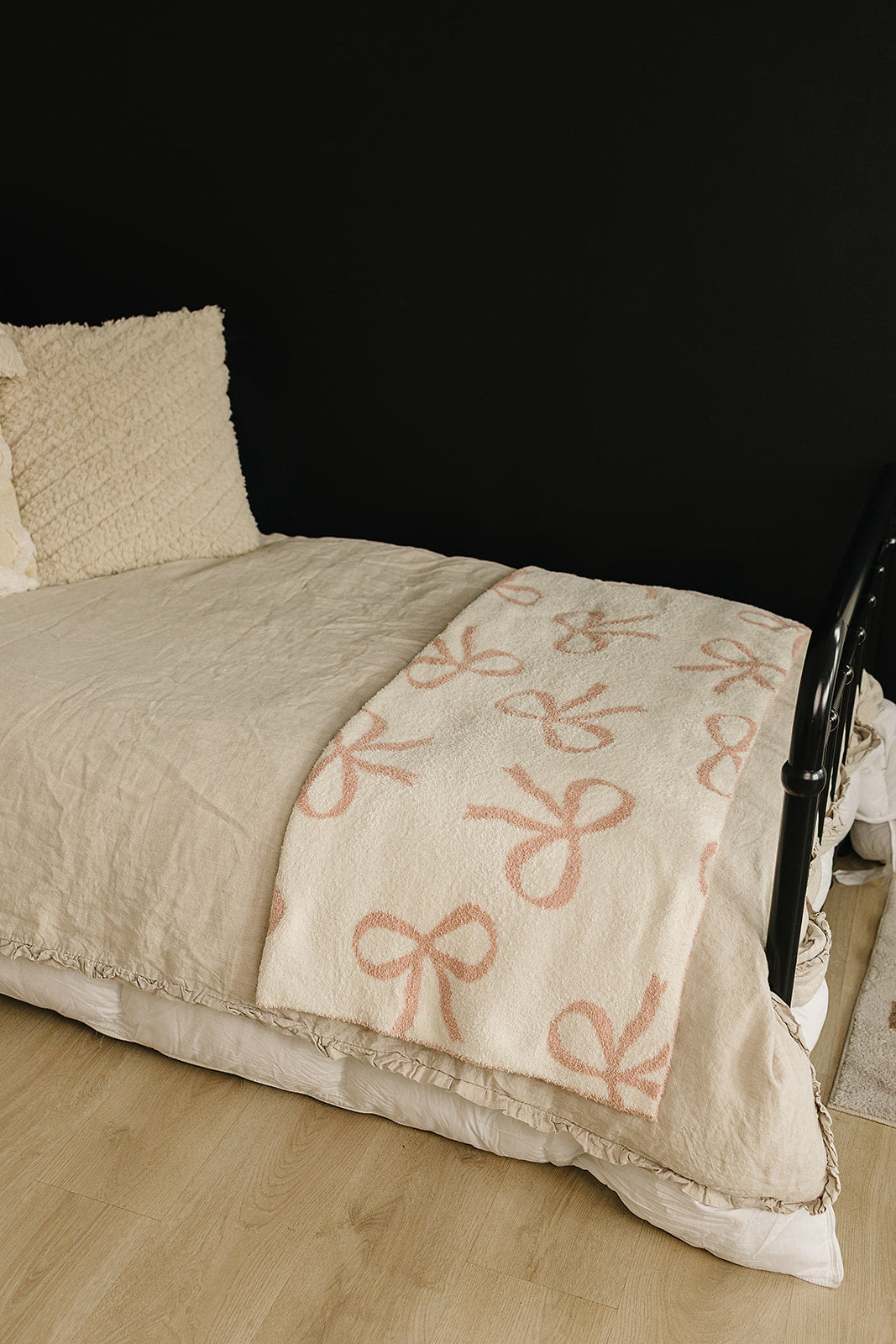 Pink Bow Plush Blanket draped on a bed, featuring a soft minky fabric and charming pink bow design.