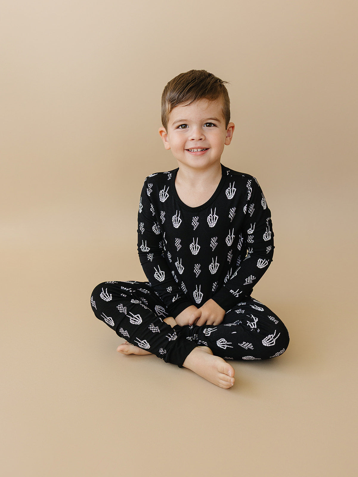 Child wearing Bamboo Two-Piece Set Skelly Vibes, featuring playful skeleton graphics and a cozy design.