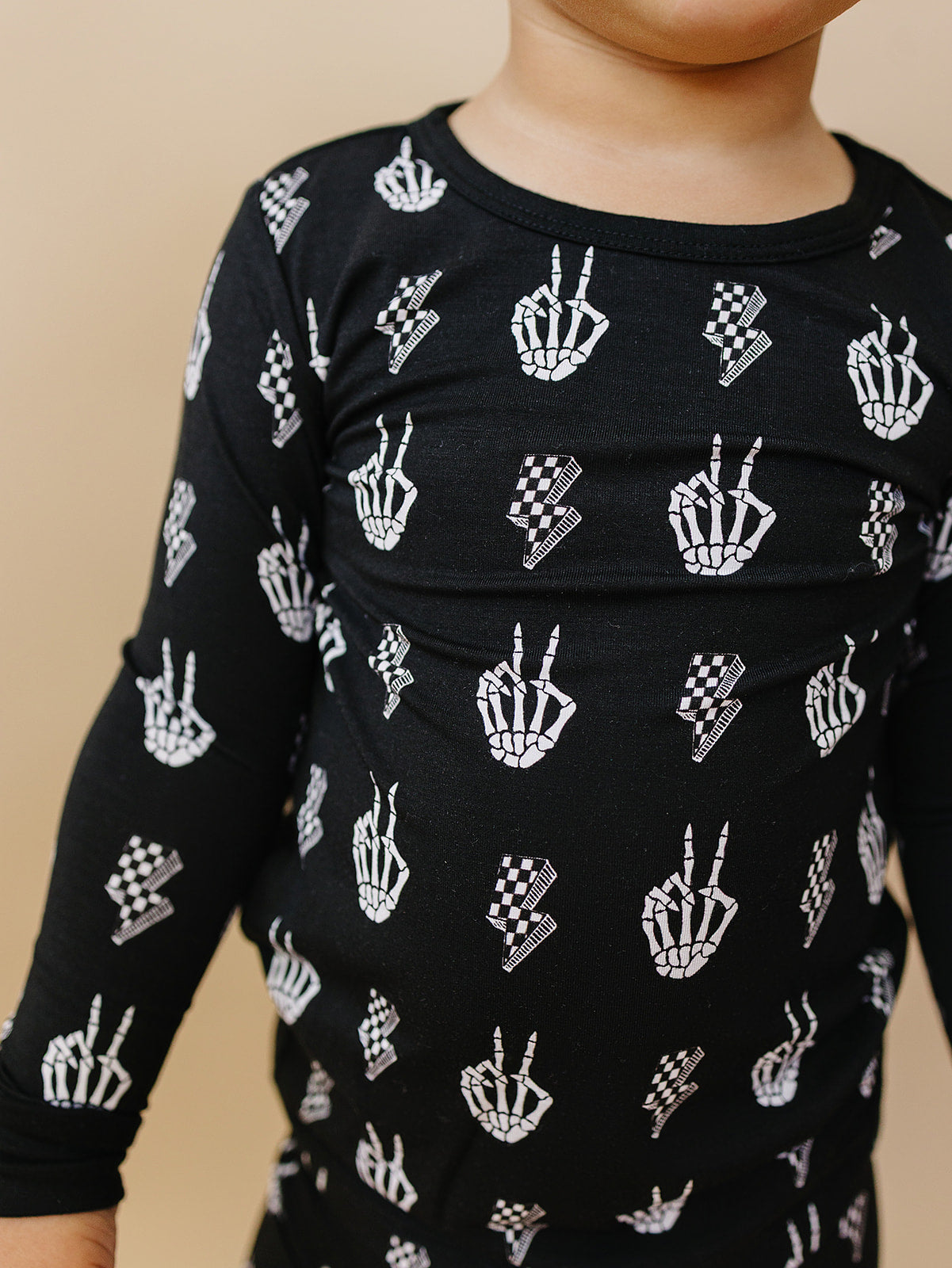 Kids wearing Bamboo Two-Piece Set Skelly Vibes, featuring playful skeleton graphics on a cozy black top.