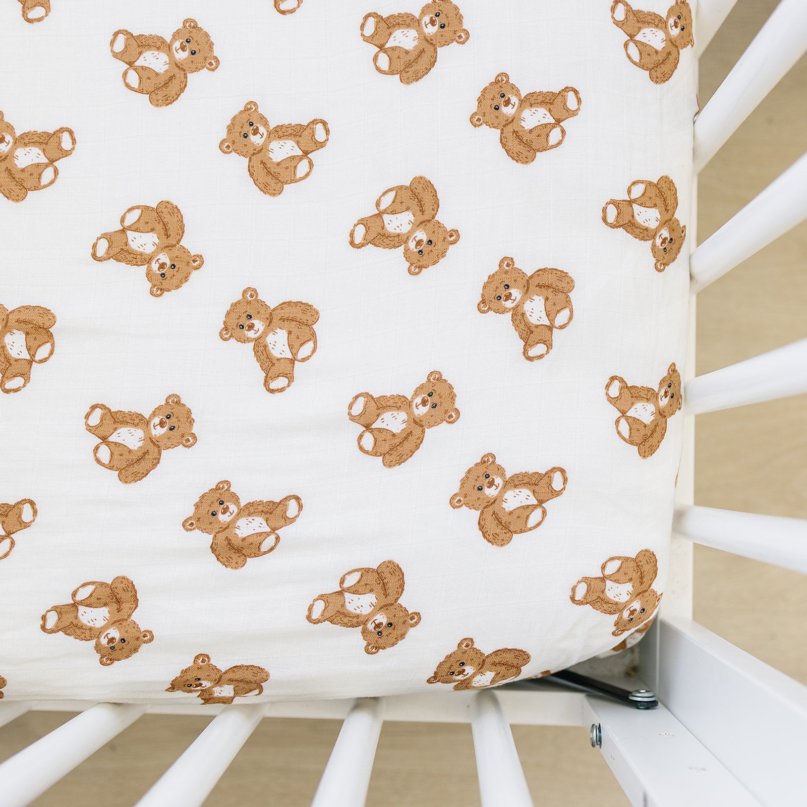 Muslin crib sheet featuring a cute teddy bear pattern in soft cotton for a cozy crib finish.