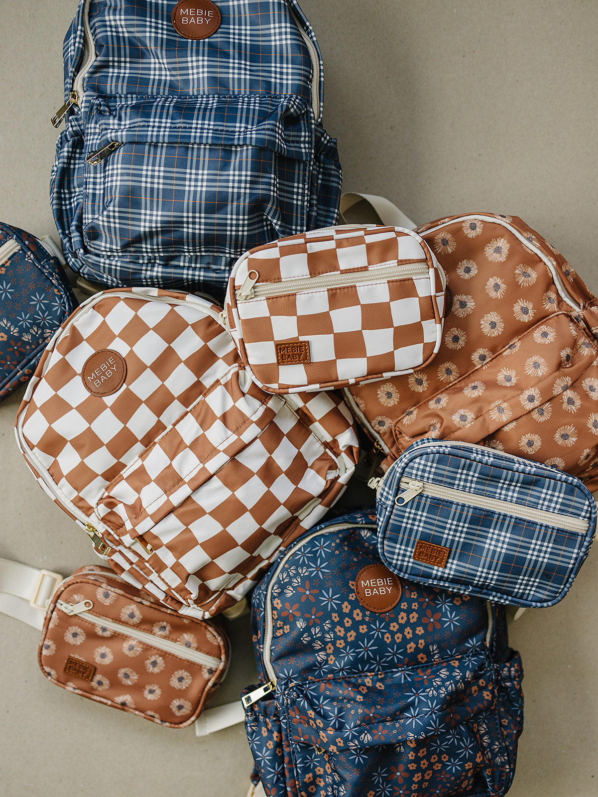Collection of stylish backpacks and pouches with checkered and floral patterns in rust and blue tones.