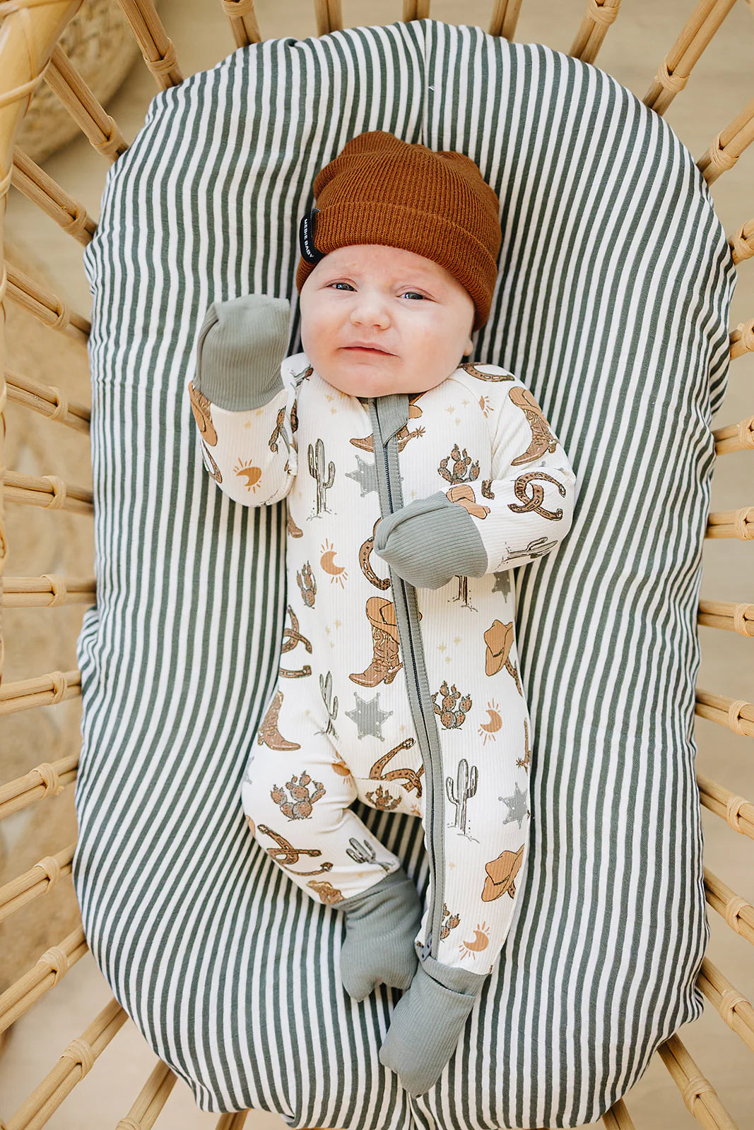 Newborn in Outlaw Cowboy bamboo zipper footie with western patterns, cozy and practical for all-day comfort.