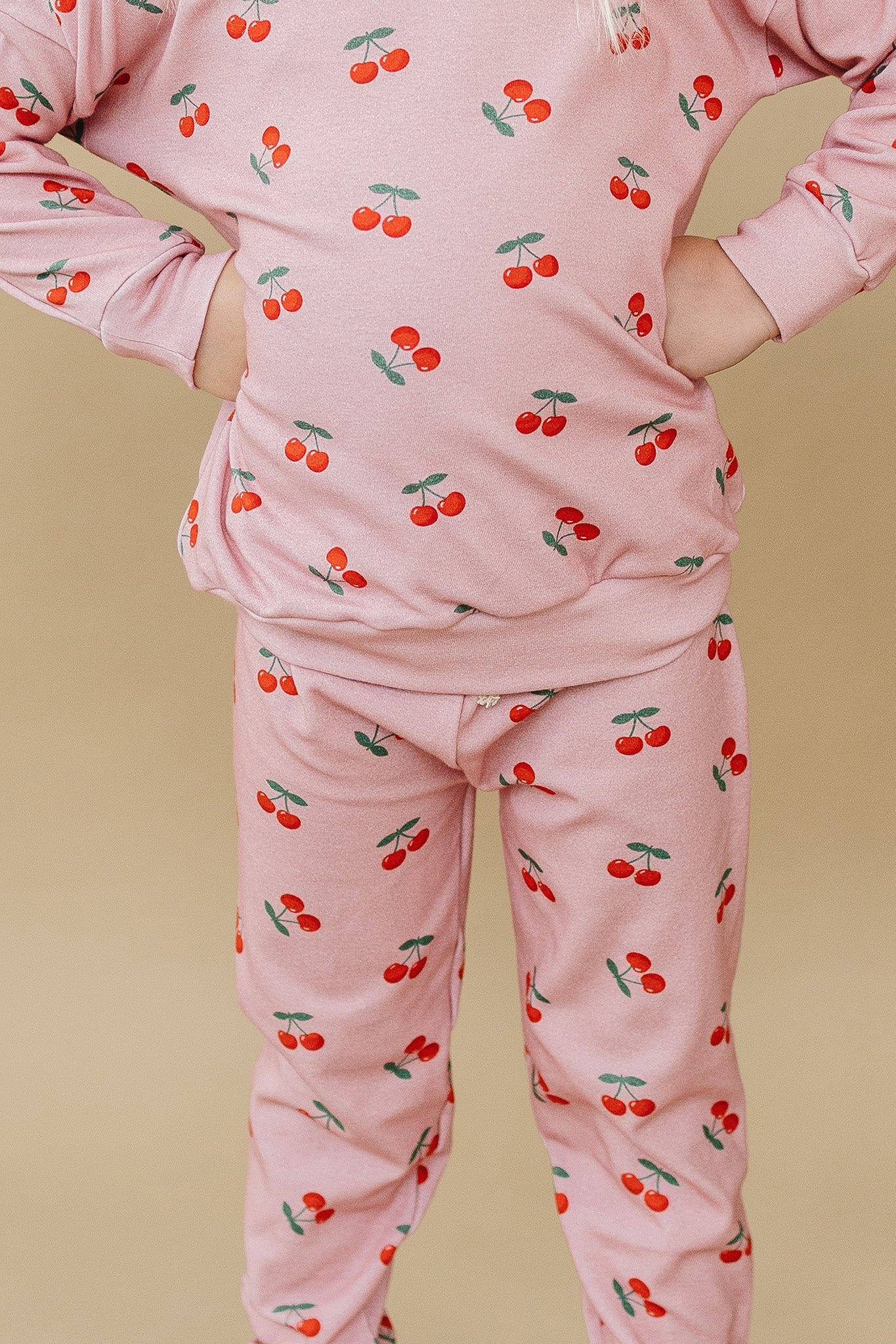 Blush Cherry Kids Lounge Set featuring a playful cherry print on a pink top and jogger-style bottoms.