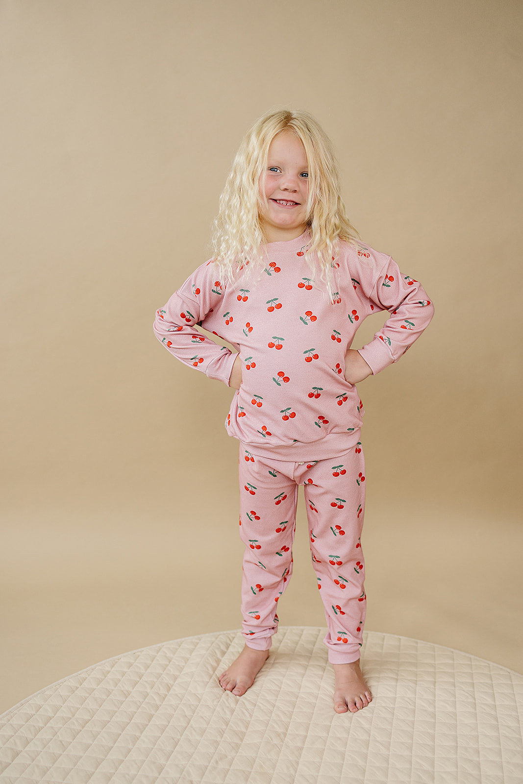 Girl wearing Blush Cherry Kids Lounge Set, a cozy two-piece outfit in soft blush with cherry print.
