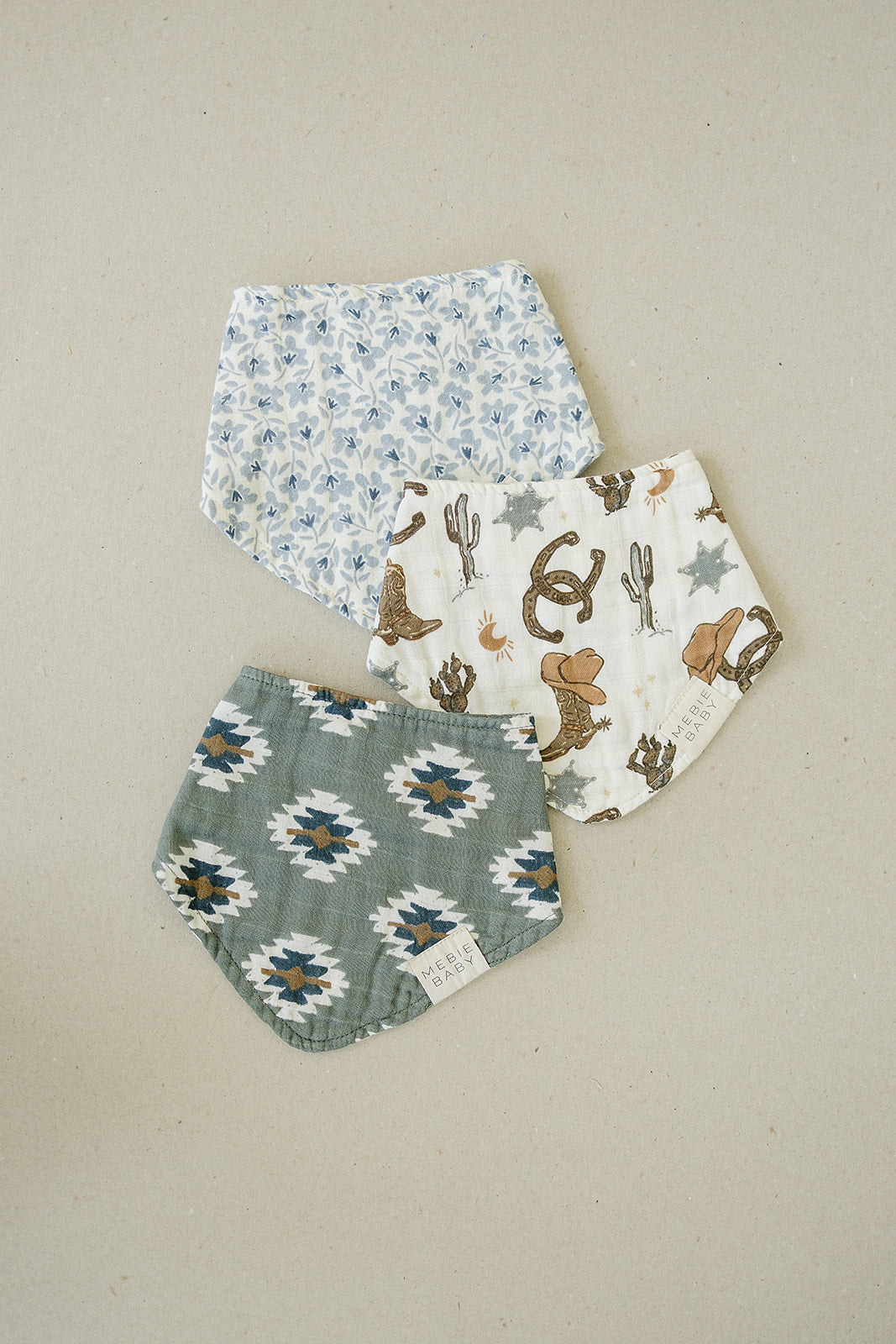 Set of three stylish muslin bibs, featuring floral and western prints, perfect for keeping babies clean and fashionable.