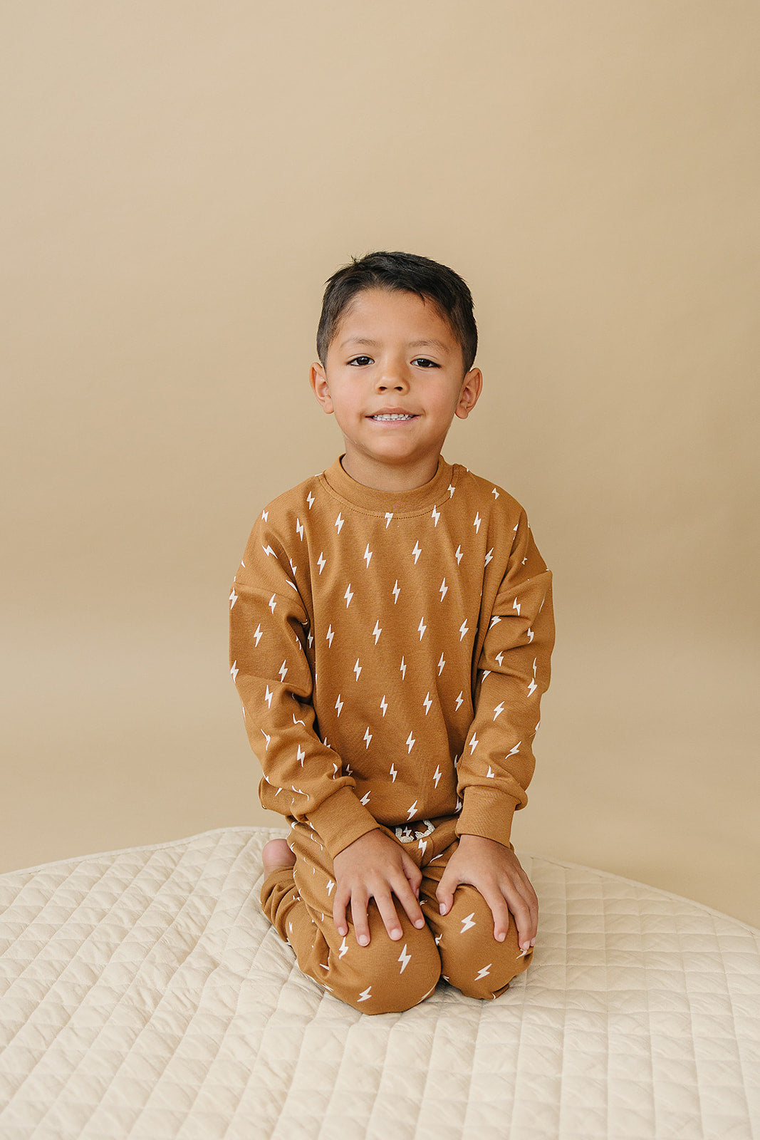 Fall Bolts Kids Lounge Set featuring a child in a brown outfit with lightning bolt print, perfect for toddlers.