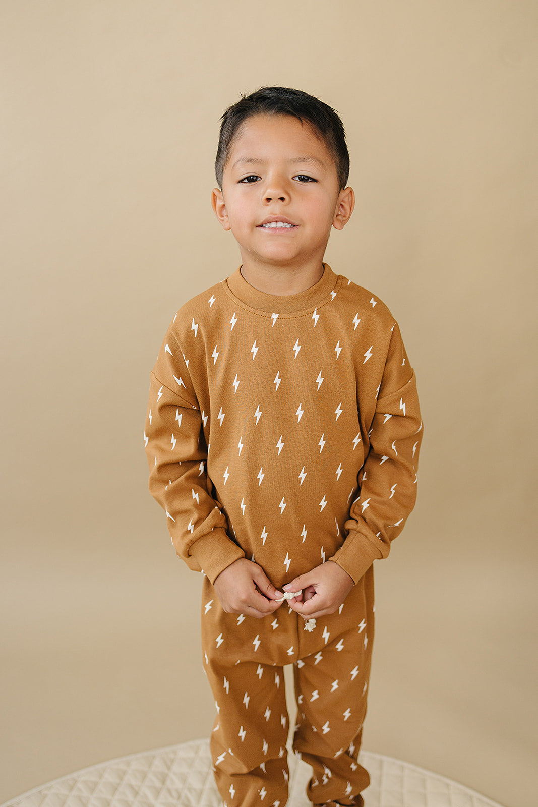 Fall Bolts Kids Lounge Set featuring a boy in a cozy lightning bolt patterned outfit with earthy tones.
