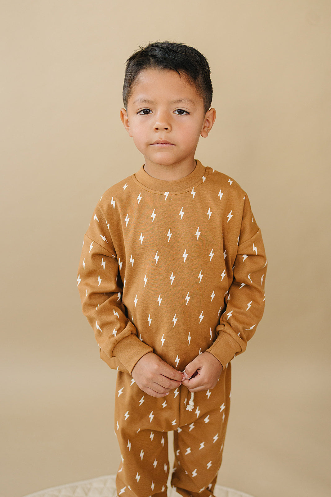 Fall Bolts Kids Lounge Set featuring a child in a brown lightning bolt print outfit, ideal for baby and toddler play.