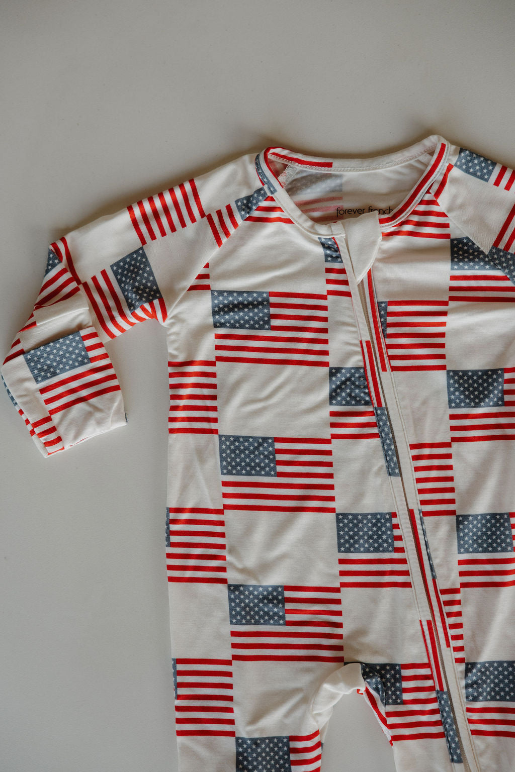 Bamboo zip pajamas featuring an allover Americana print with stars and stripes in red, white, and blue, perfect for summer.