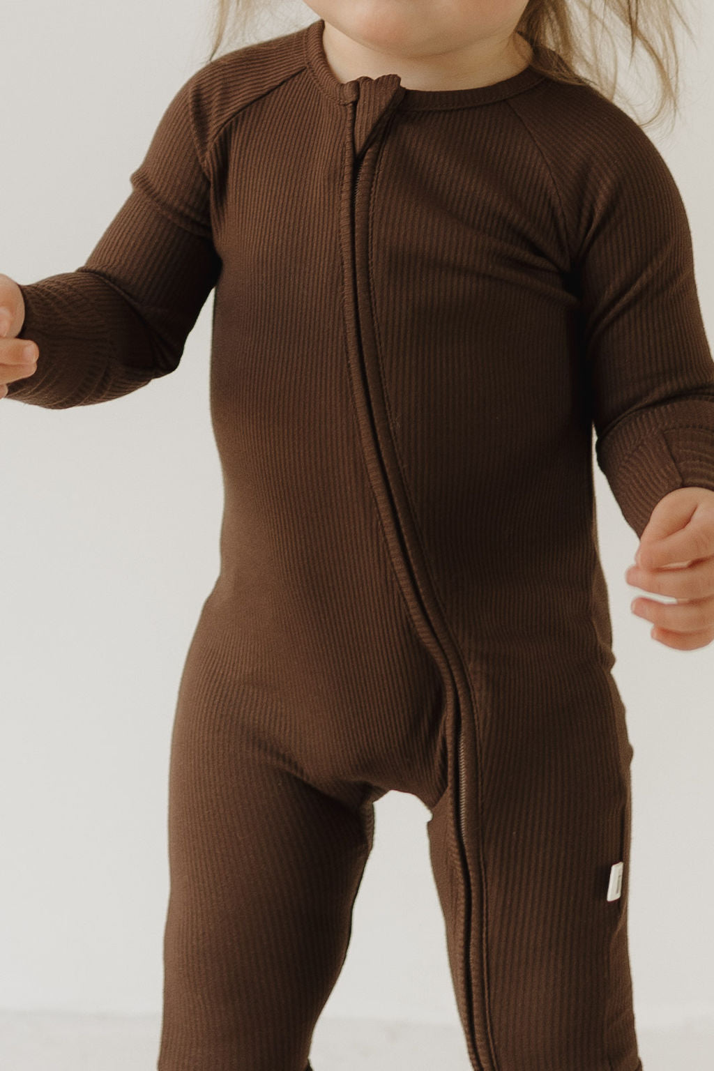 Child wearing cozy bamboo zip pajamas in rich Coffee Bean color, perfect for lounging and warm cuddles.