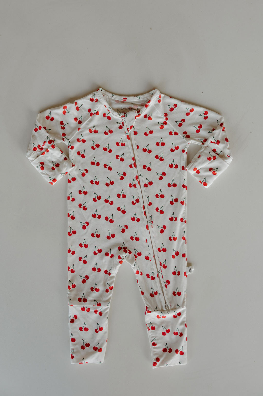 Bamboo zip pajamas featuring a playful cherry print on a soft pink base, perfect for cozy sleepwear.