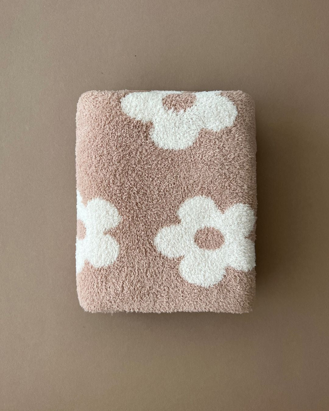 Daisy Fuzzy Blanket in latte color, featuring soft fabric and flower pattern, perfect for cozy snuggles and naps.