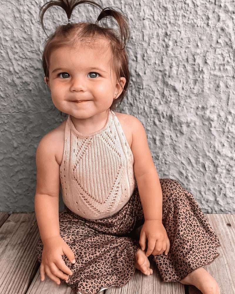 Baby wearing a soft Drake crochet halter romper with a delicate crochet neckline and playful leopard print pants.