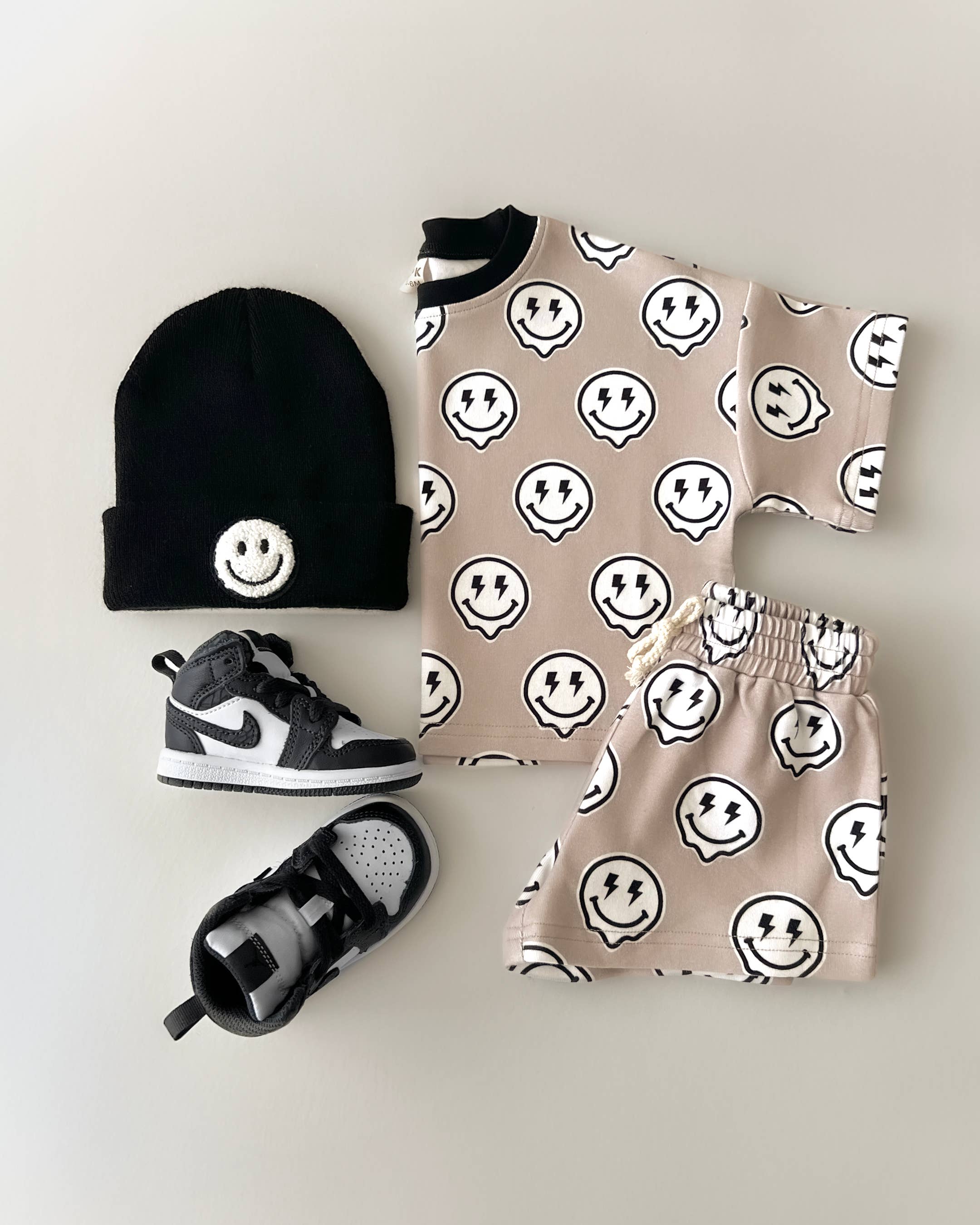 Electric Drippy toddler shorts set featuring smiley face print tee, matching shorts, beanie, and sneakers.
