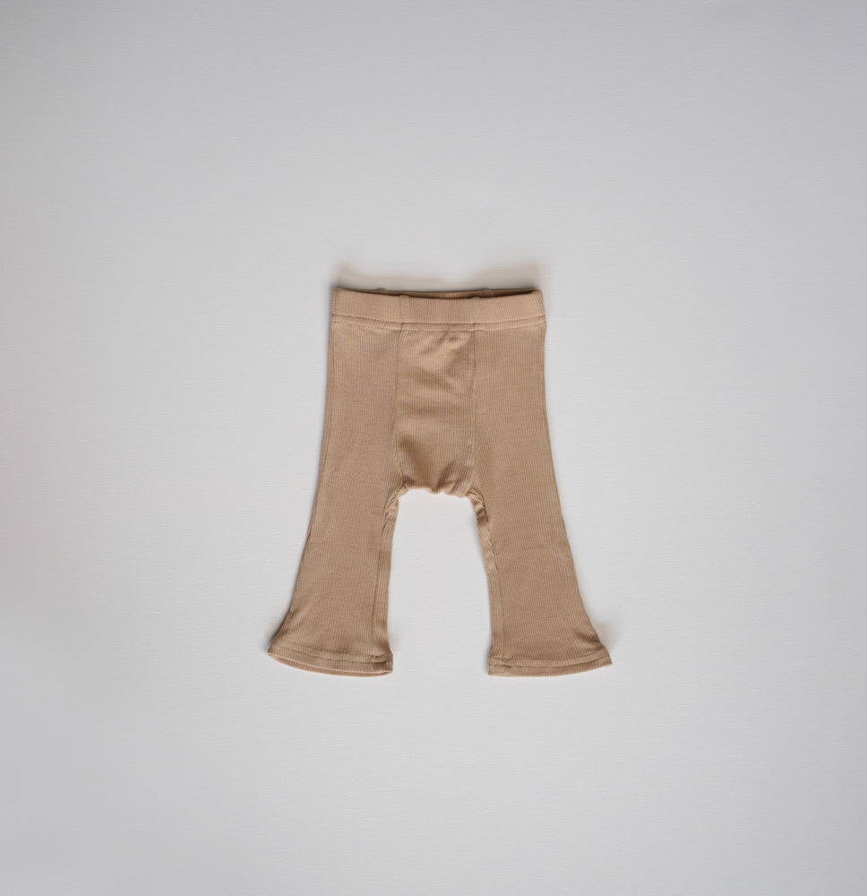 Ribbed Modal Flare Pant - Stretchy Neutral Flare Bottoms in soft tan color on a gray background.