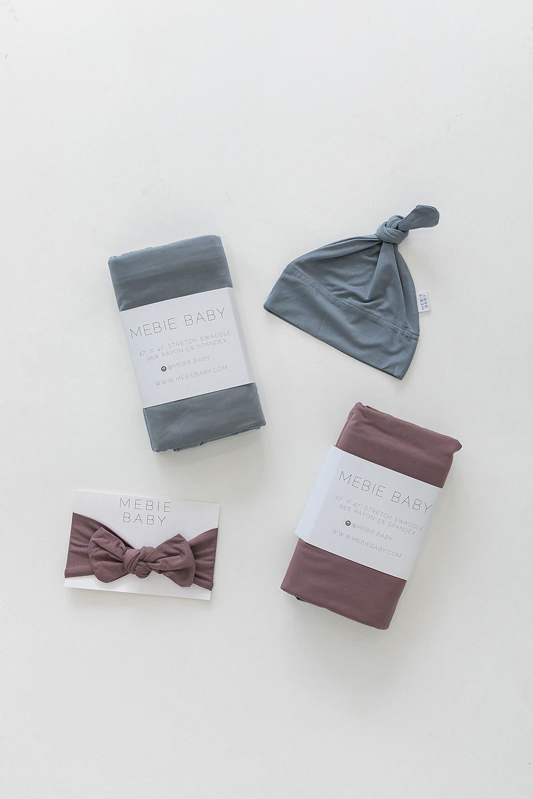 Bamboo Stretch Swaddle Dusty Blue set with coordinating hat and headband, showcasing soft, stylish baby accessories.