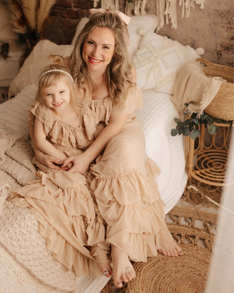 Mom and daughter wearing matching champagne ruffle dresses, showcasing a stylish and sweet moment together.